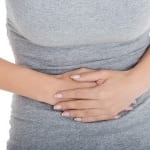 Woman holding her stomach because of abdominal pain.