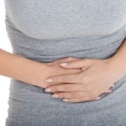 Woman holding her stomach because of abdominal pain.