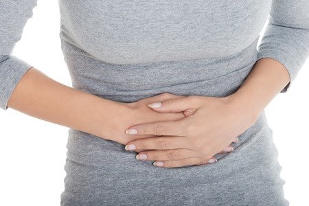 Woman holding her stomach because of abdominal pain.