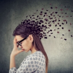 Young woman losing parts of head as symbol of decreased mind function.