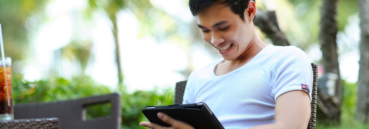 Man looking down at handheld device, straining neck.