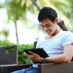 Man looking down at handheld device, straining neck.