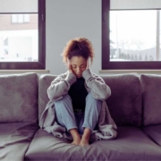 Woman with a migraine on sofa.